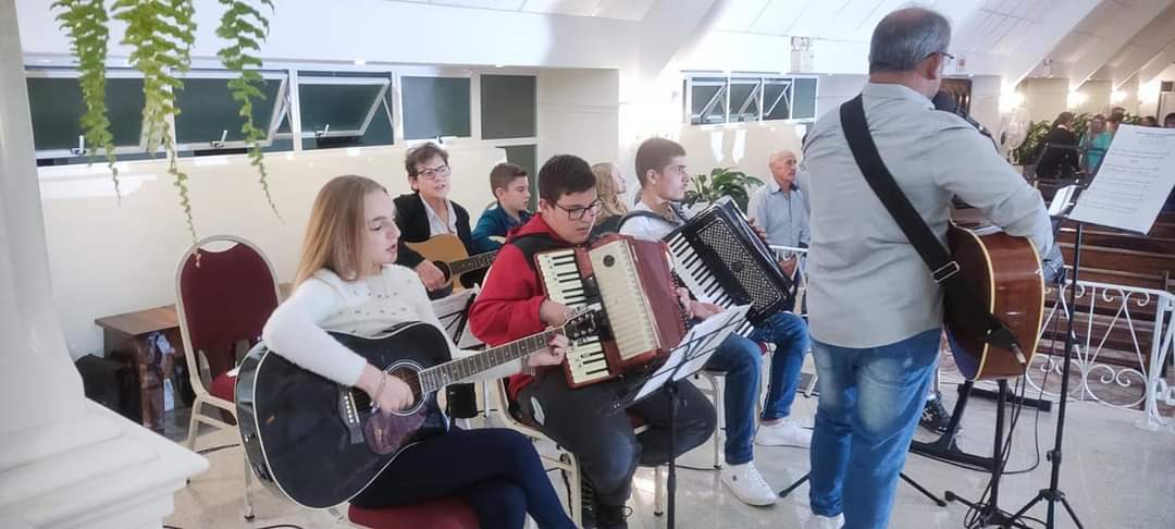 Alunos em apresentação com violões e acordeon